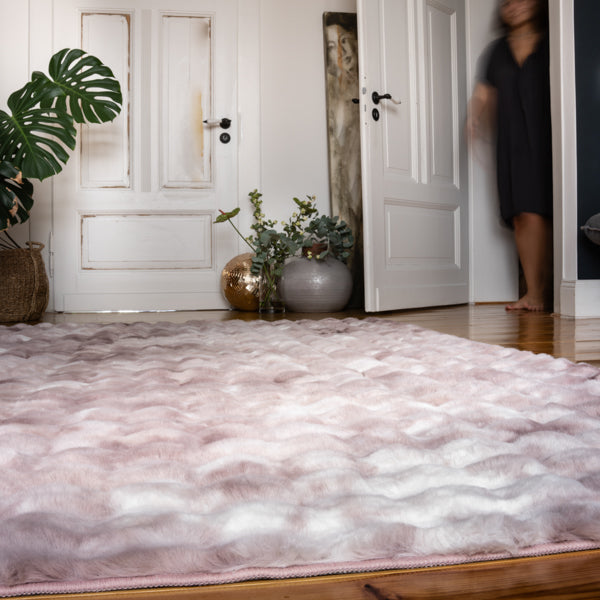 Sfeervolle woonkamer met het roze Lalee.Avenue vloerkleed als warme blikvanger op houten vloer.