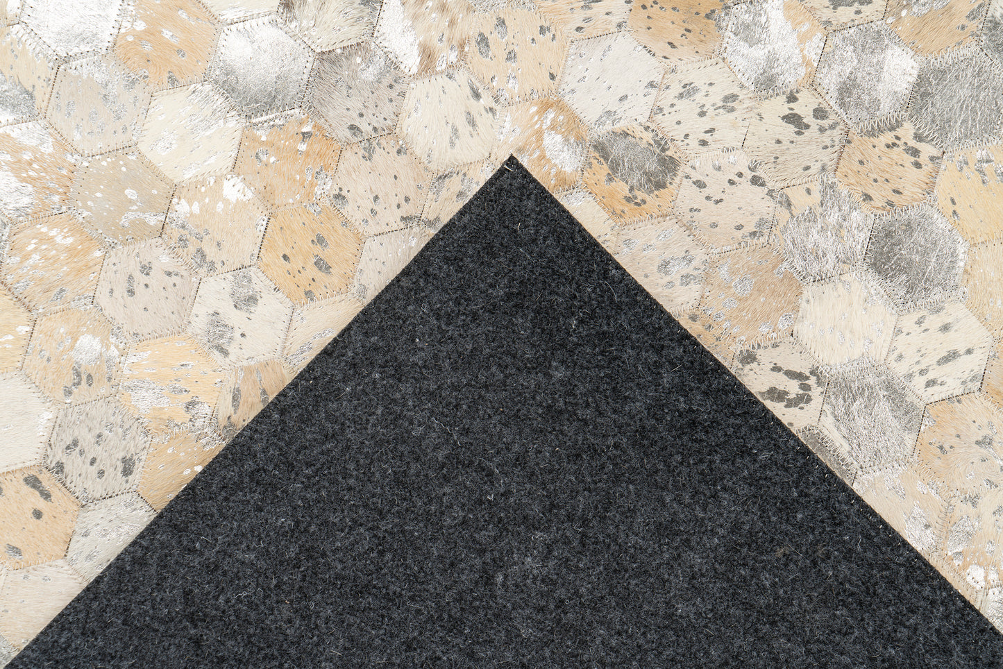 Achterkant van het LaleeAvenue vloerkleed Lanvin, zwart viltmateriaal met zichtbare handgemaakte hexagon-leren bovenkant in goud- en zilvertinten.