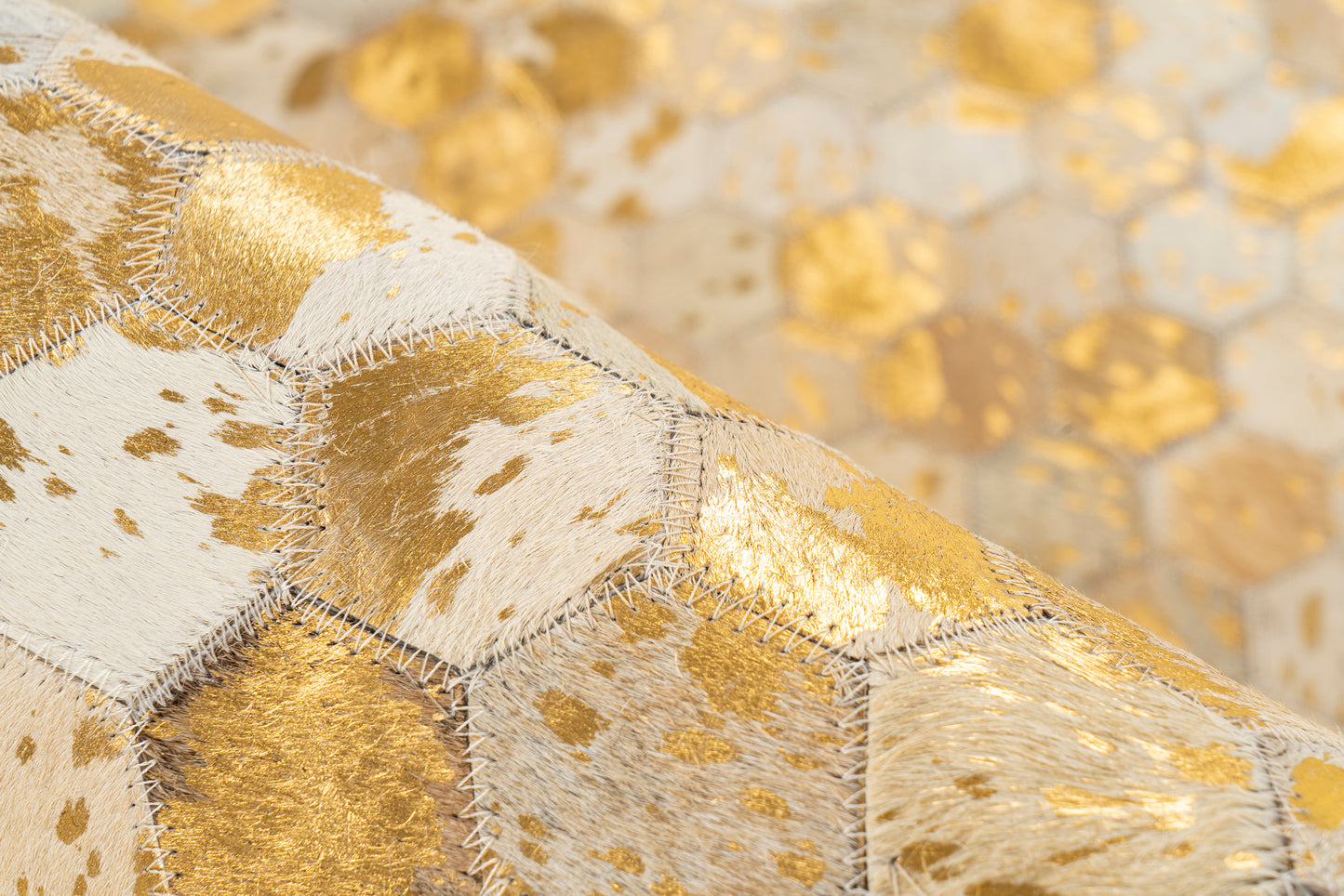 Close-up van het Lanvin 1025 vloerkleed van echt leer met gouden details en handgestikte afwerking