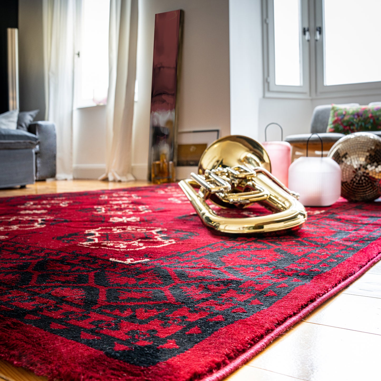 Rood handgemaakt vloerkleed My Ariana 881 in luxe woonkamer met trombone en houten vloer
