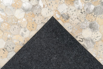 Achterkant van het LaleeAvenue vloerkleed Lanvin, zwart viltmateriaal met zichtbare handgemaakte hexagon-leren bovenkant in goud- en zilvertinten.