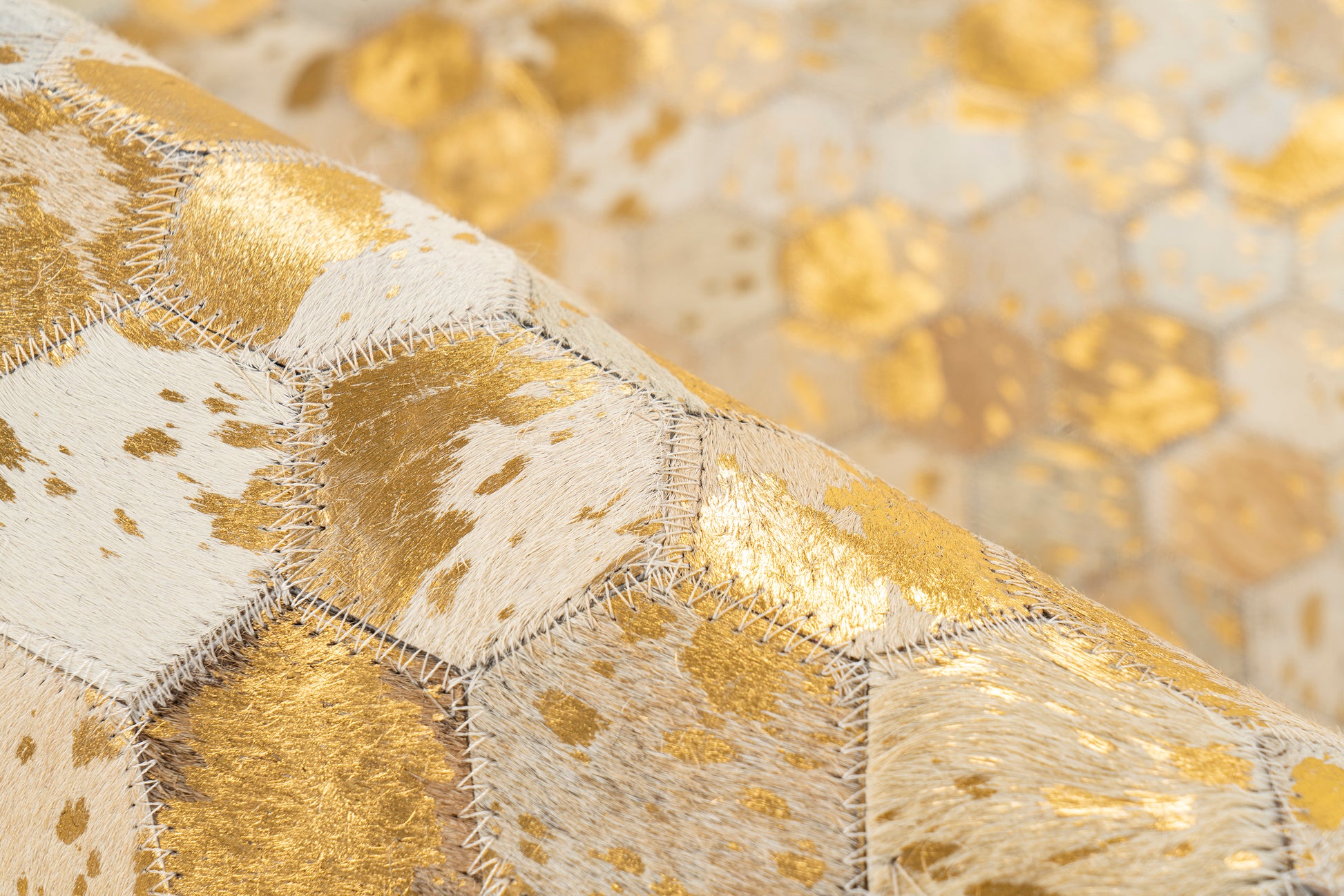 Close-up van het Lanvin 1025 vloerkleed van echt leer met gouden details en handgestikte afwerking